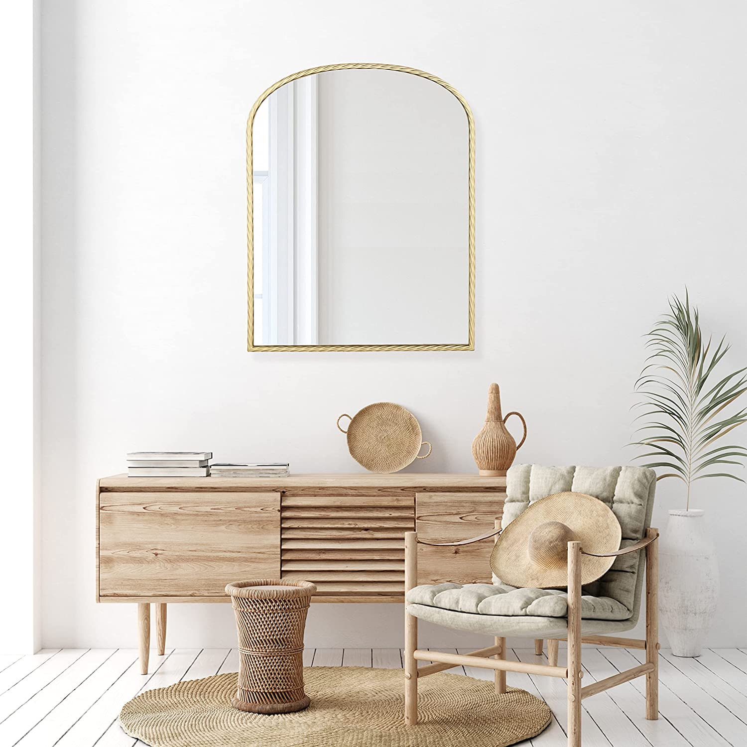 a gold arch mirror above a neutral color console table pairs with rustic decors