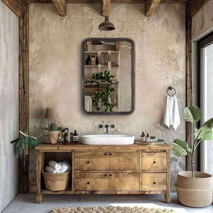 an antique rectangular mirror above a wooden vanity in natural wood finish