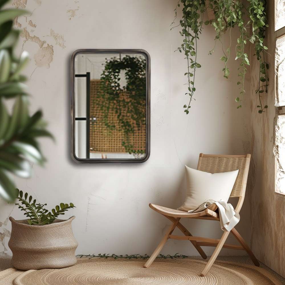 A cozy relaxation corner with a comfortable single chair showcases a matte finish rectangular mirror small on the wall, adding a subtle touch of elegance