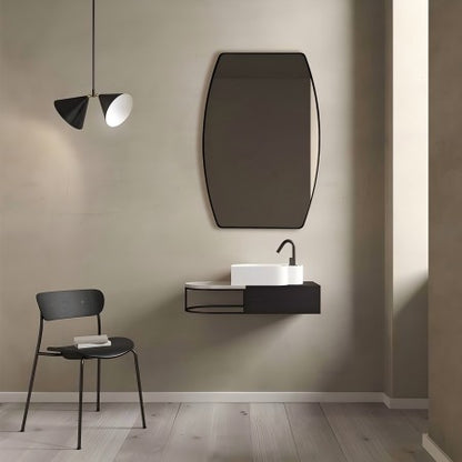 in a minimalist modern bathroom, a black oval mirror complements a black chair, black chandelier, and black sink for a cohesive look