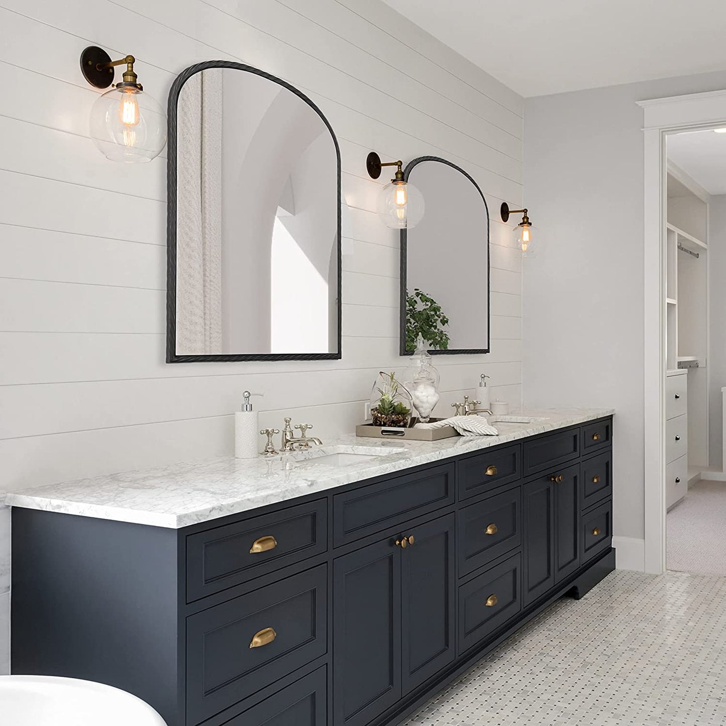 two large arched black metal wall mirrors above a double vanity